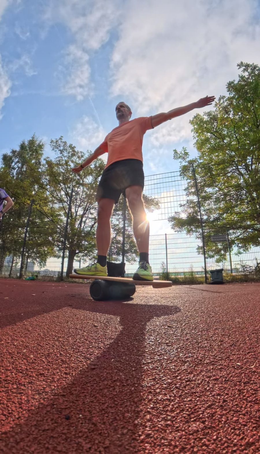 Heiko Bartlog balanciert im Freien auf einem Balance-Board, Arme ausgestreckt.