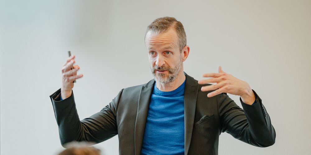 Heiko Bartlog erklärt gestikulierend einen Sachverhalt vor einer Gruppe.